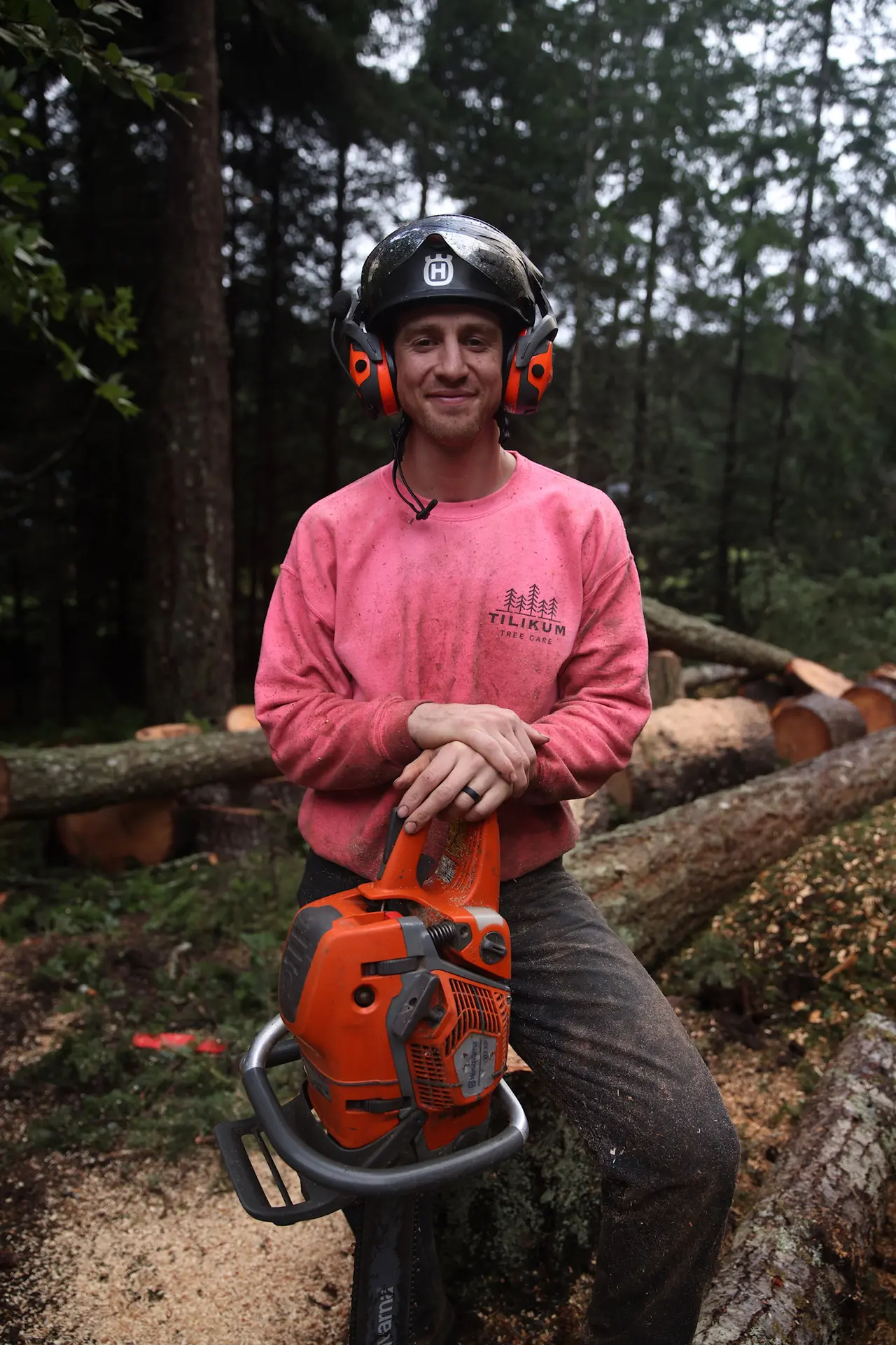 Tilikum Tree Care arborist in pink shirt holding chainsaw, Southern Oregon Coast